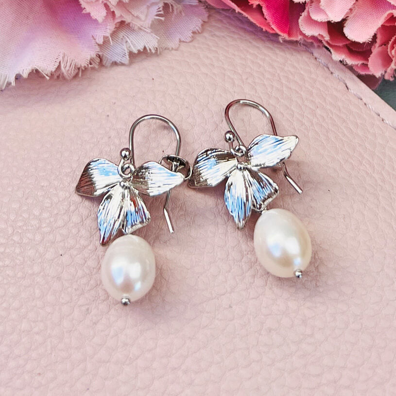 Silberfarbener Ohrhänger und vierblättrige Blüte mit edler Süßwasserperle von Janne von der Heide