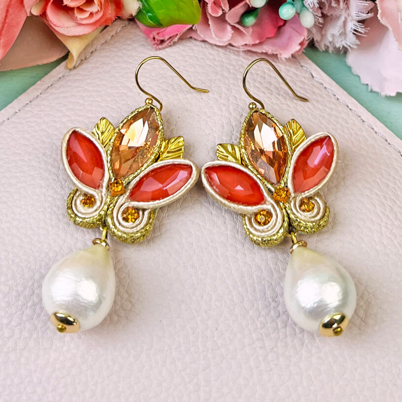 Schöne Soutache-Ohrhänger in Gold und koralligem Pink mit Baumwolltropfen