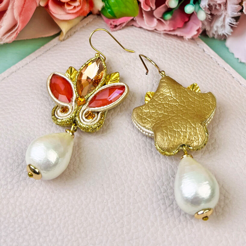 Schöne Soutache-Ohrhänger in Gold und koralligem Pink mit Baumwolltropfen