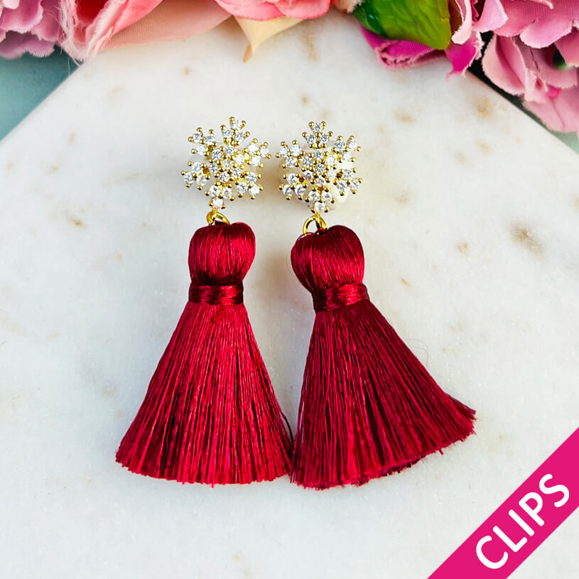 Funkelnder Schneeflocken-Ohrclips mit Steinen und roter Quaste