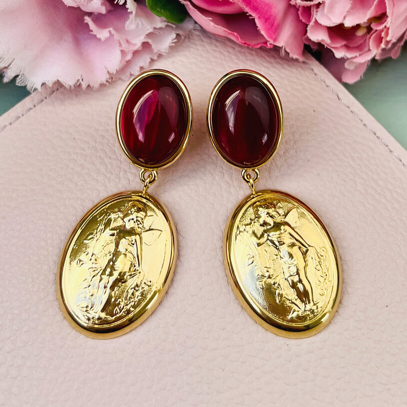 Dunkelrote Ohrstecker mit Putte auf goldenem Oval