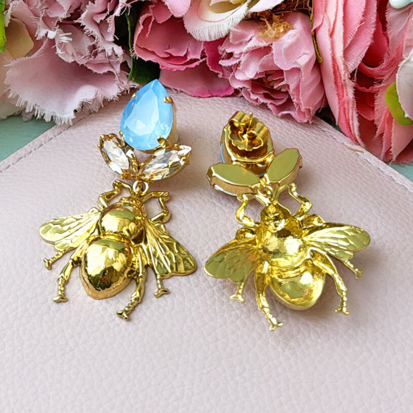 Funkelnde Ohrstecker in Eisblau und Champagner mit vergoldeter Hummel