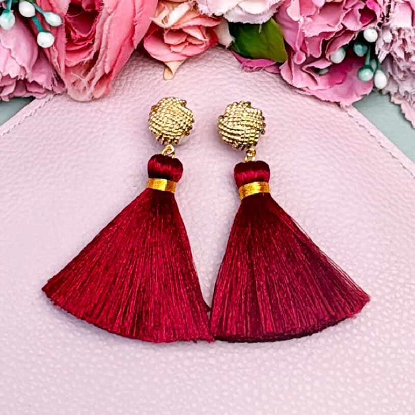 Vergoldete Knoten-Ohrstecker mit dunkelroter Quaste