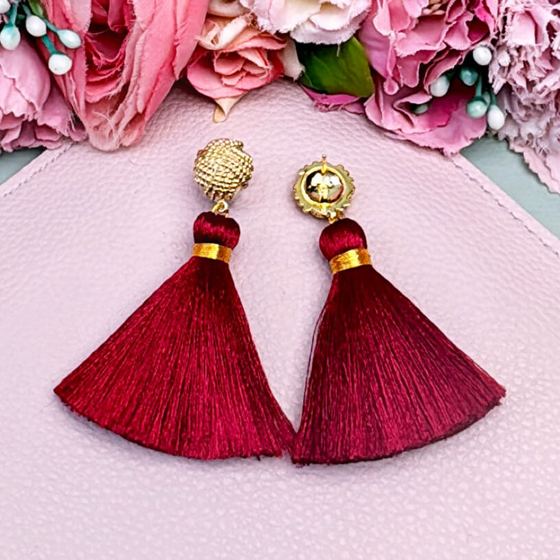 Vergoldete Knoten-Ohrstecker mit dunkelroter Quaste