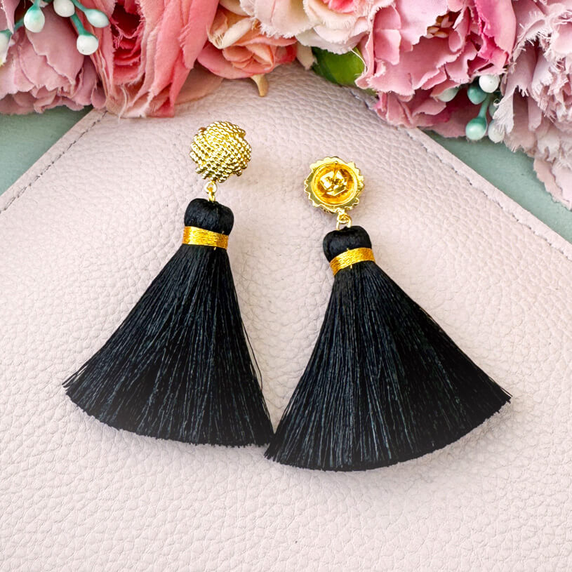 Vergoldete Knoten-Ohrstecker mit schwarzer Quaste