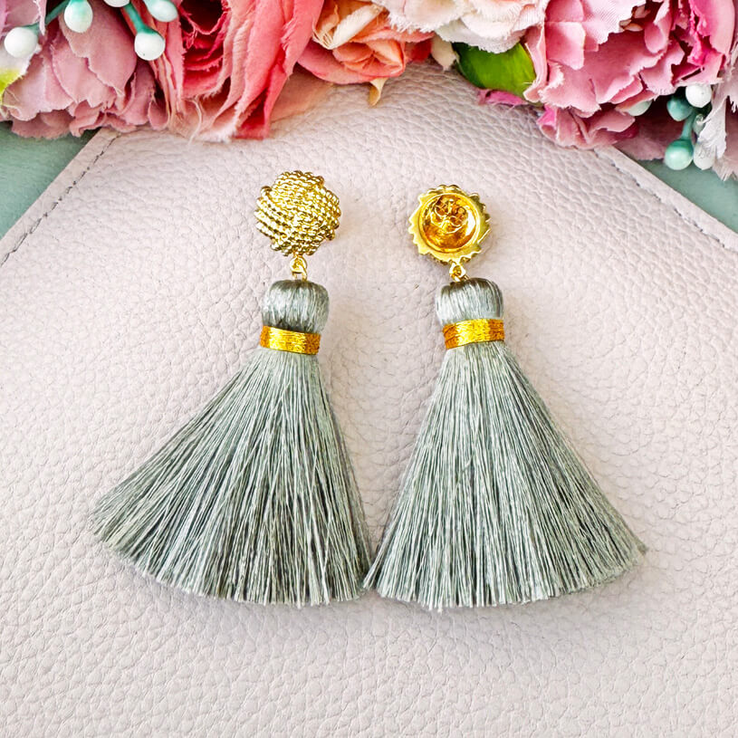 Vergoldete Knoten-Ohrstecker mit hellgrauer Quaste