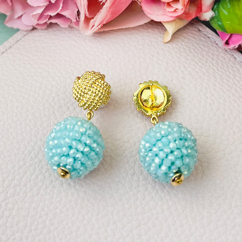 Vergoldete Knoten-Ohrringe mit funkelnden Kugeln in Hellblau