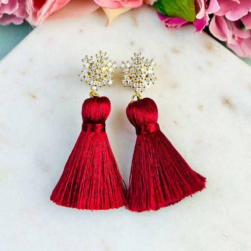 Funkelnder Schneeflocken-Ohrstecker mit Steinen und roter Quaste