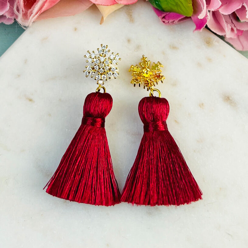 Funkelnder Schneeflocken-Ohrstecker mit Steinen und roter Quaste