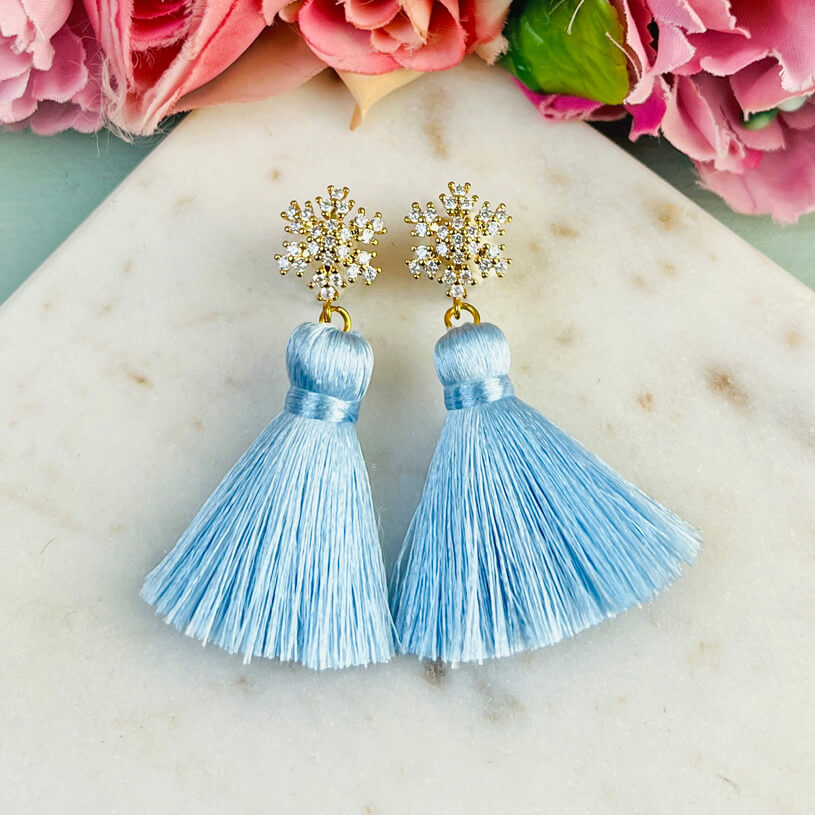 Funkelnder Schneeflocken-Ohrstecker mit Steinen und hellblauer Quaste