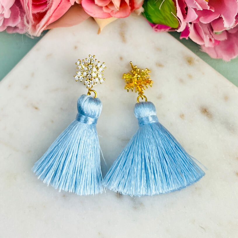 Funkelnder Schneeflocken-Ohrstecker mit Steinen und hellblauer Quaste