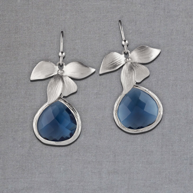 Silberfarbener Ohrhänger und vierblättrige Blüte mit Tropfen in Nachtblau von Janne von der Heide