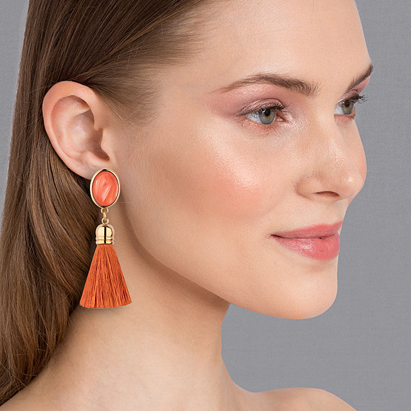 Schimmernde korallenfarbene Ohrstecker mit seidigen Quasten