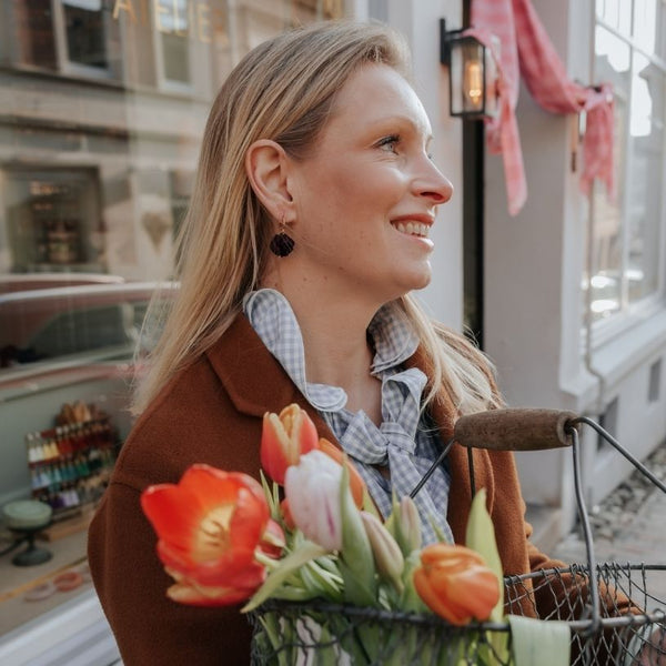 Vergoldete Creolen mit schwarzem Blüten-Pompom