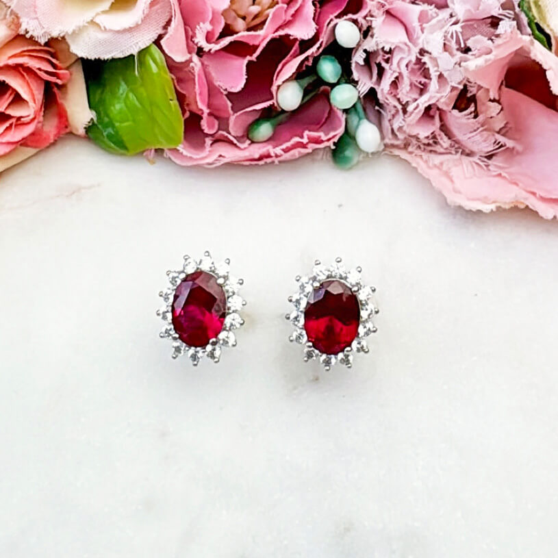 Strahlende silberfarbene Ohrstecker mit ovalem Kristall in Rot