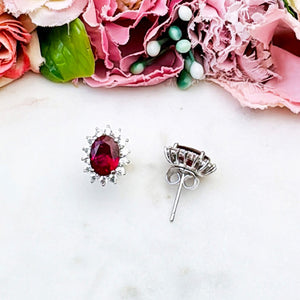 Strahlende silberfarbene Ohrstecker mit ovalem Kristall in Rot