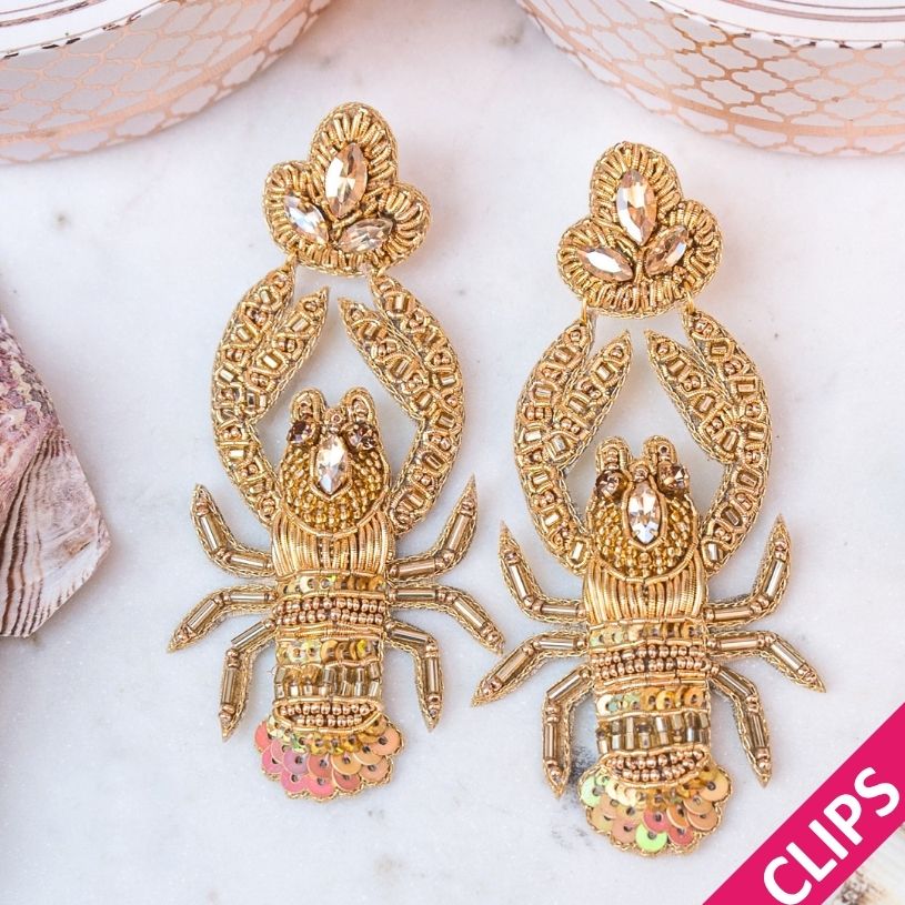 Auffällige Soutache-Ohrclips als goldfarbener Hummer