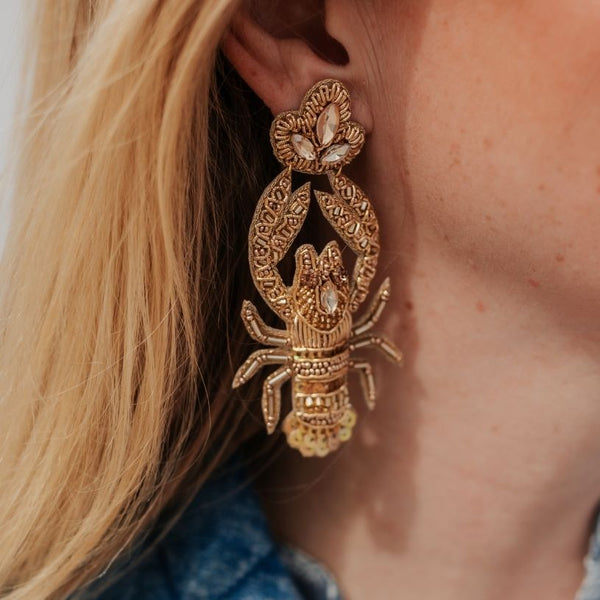 Auffällige Soutache-Ohrringe als goldfarbener Hummer