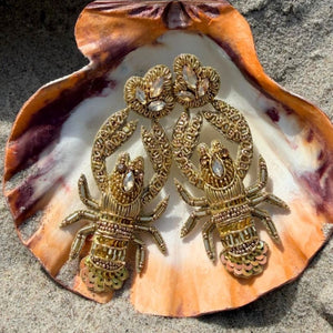 Auffällige Soutache-Ohrringe als goldfarbener Hummer