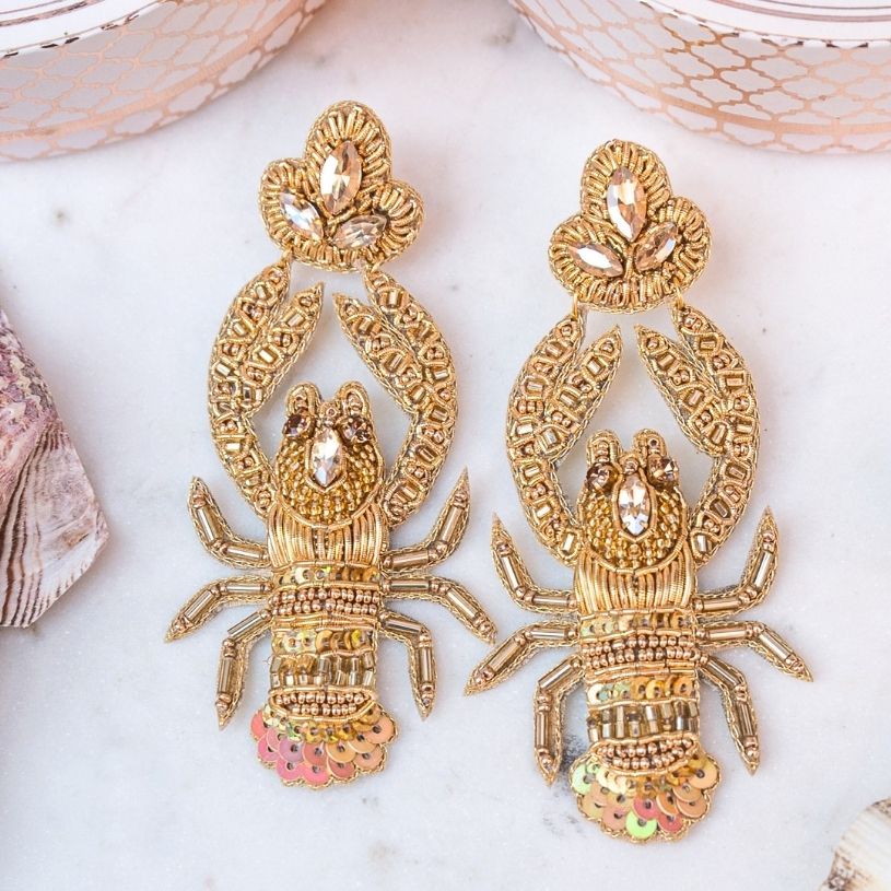 Auffällige Soutache-Ohrringe als goldfarbener Hummer