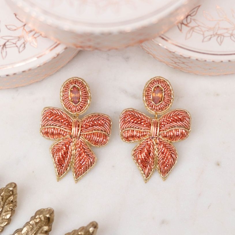 Elegante lachsrosafarbene Soutache-Ohrringe als Schleife