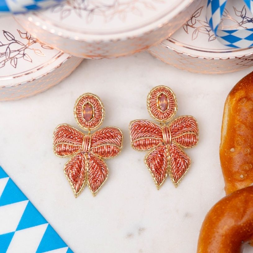Elegante lachsrosafarbene Soutache-Ohrringe als Schleife